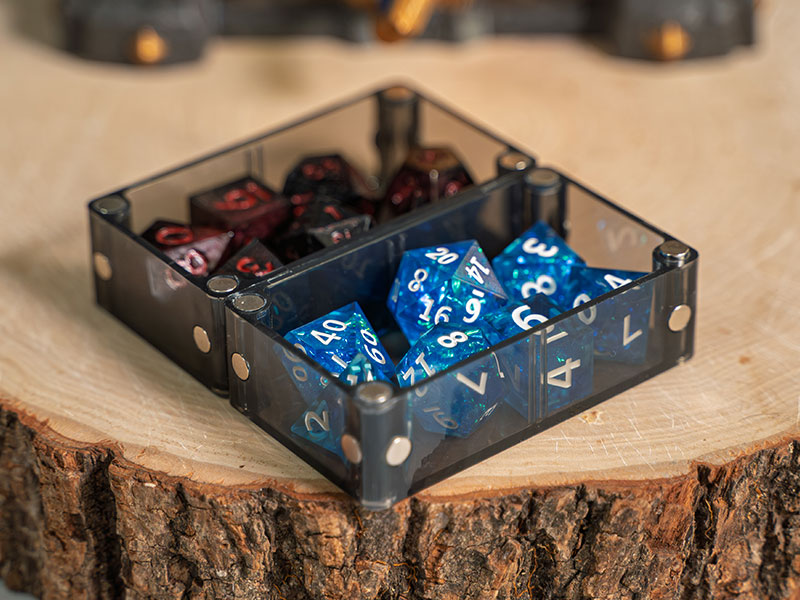 A Single on a wooden table, its two compartments holding blue and dark red dice