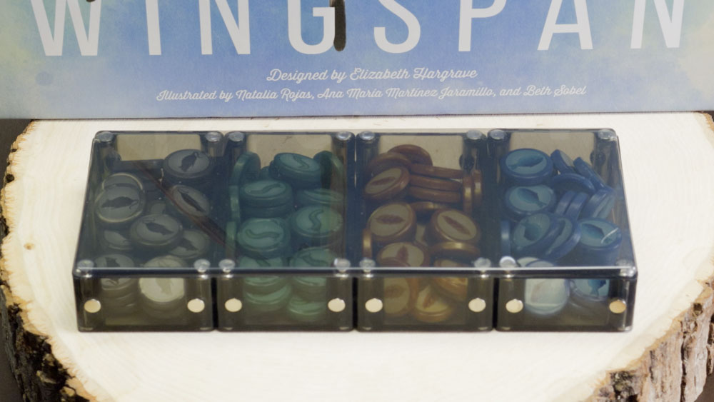 A Unity Vault Lid spanning four trays of Wingspan food tokens, with the Wingspan box behind
